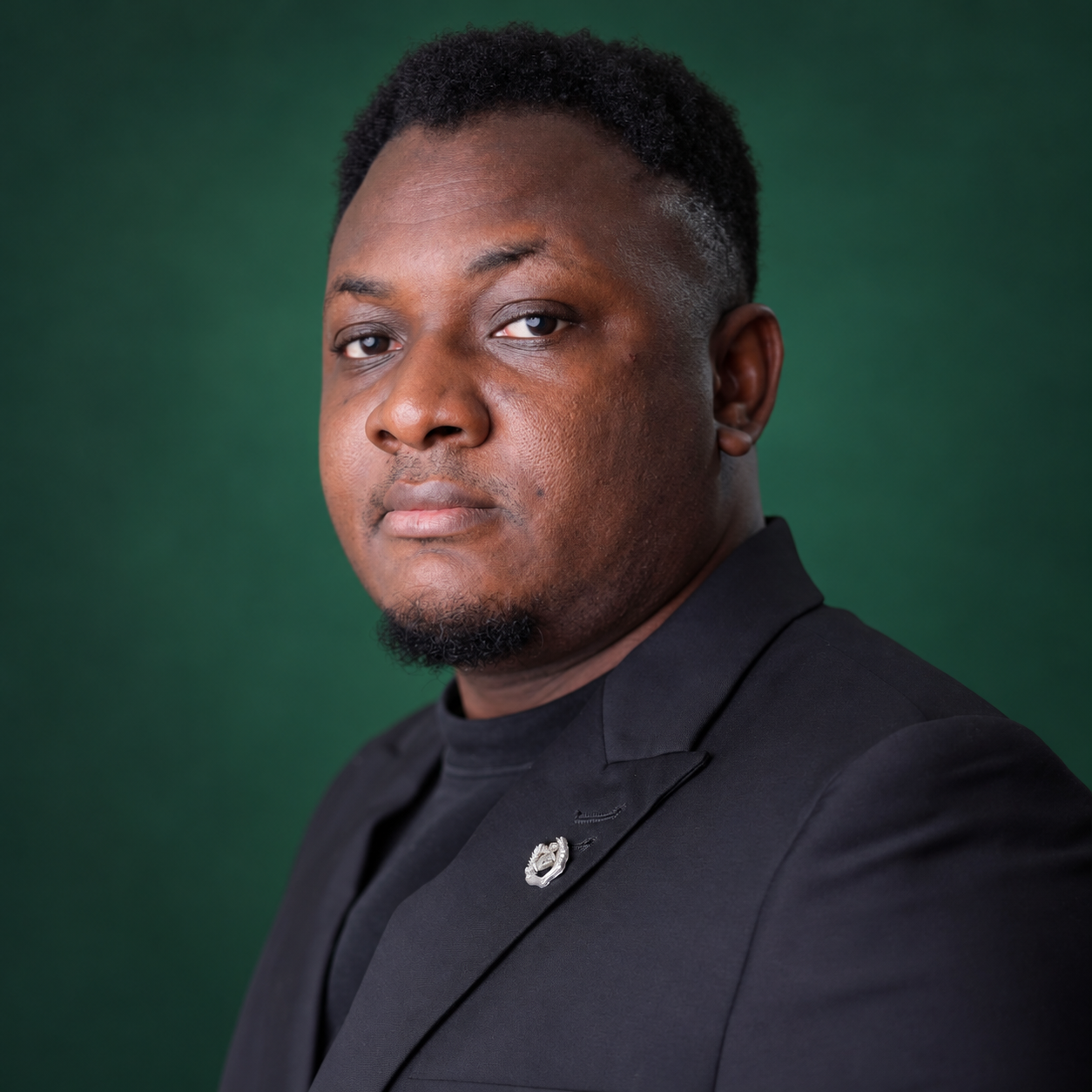 Joseph Abara, founder of Butterflystack, against a dark green studio background